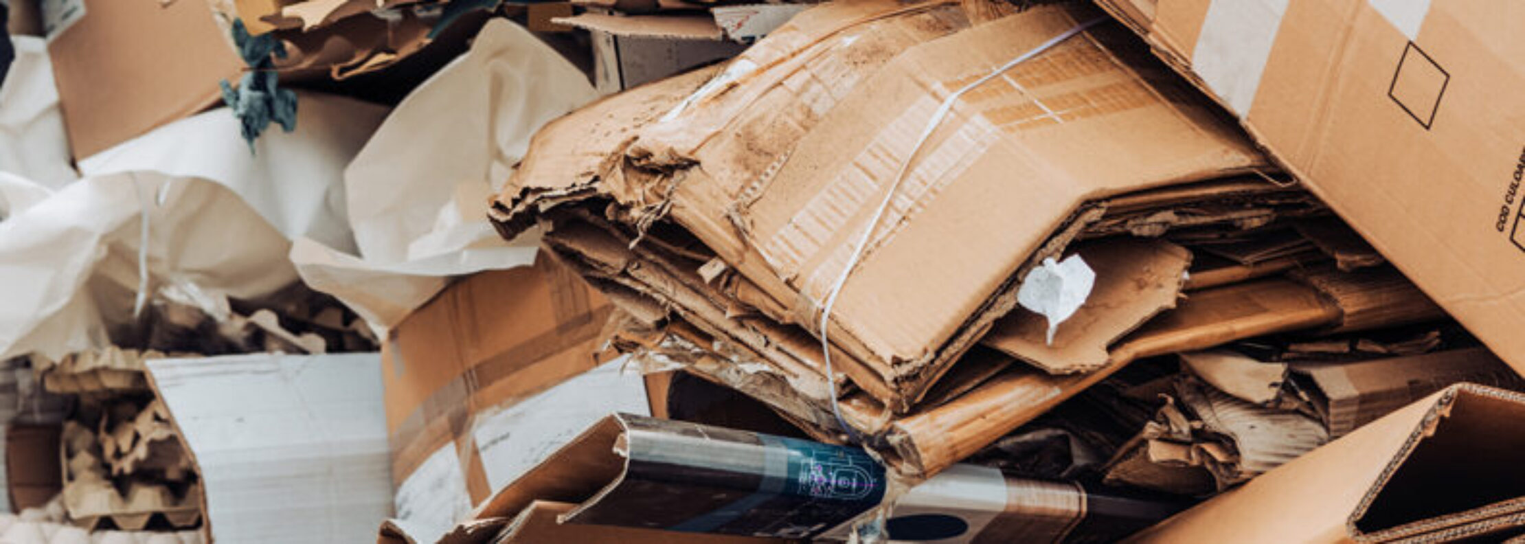 Cardboard waste pile stacked on a landfill. Recycled paper or reuse concept